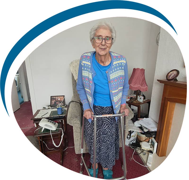 Old woman using zimmerframe at home in Flintshire